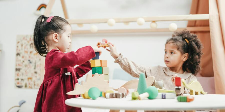 Two toddlers play with blocks