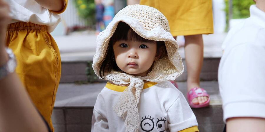 Cute little girl wearing scarf made up of wool looking at us